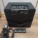 Černý kytarový kombozesilovač s ovládacím panelem v horní části. Na zadním panelu jsou nápisy „BUILT BY VOX Special Parts Limited“, „Vox Amplificatio…