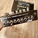 Černý efektový procesor s nápisem BOSS GT-1000CORE GUITAR EFFECTS PROCESSOR. Na zadním panelu jsou vstupy a výstupy s popisky INPUT R/MONO, L, SEND 1…