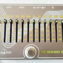 Stříbrný ekvalizér s nápisem Ca dine a 10 BAND EQ. Zařízení obsahuje 12 posuvníků s žlutými popisky: VOL, 31.25, 62.5, 125, 250, 500, 1K, 2K, 4K, 8K,…