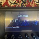 Detailní pohled na displej kytarového procesoru. Na obrazovce je vidět logo LINE 6, název modelu HELIX LT a nápis Firmware Version 3.80.0. Zařízení j…