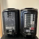 Dvě černé přenosné PA systémy značky YAMAHA. Levý kus má na zadní straně schéma zapojení a nápis STAGESPACE 400N PORTABLE PA SYSTEM. Pravý kus ukazuj…