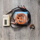 Sada příslušenství složená z bílého ladičky KORG CA-2, balení strun D'Addario XL EXL110 NICKEL WOUND 10-46, černého kabelu s několika konektory a mal…