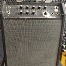 Černý kytarový kombo zesilovač s šedou síťovinou reproduktoru. Na horním ovládacím panelu jsou knofíky s popisky GAIN, BASS, TREBLE, MIDDLE a REVERB,…