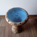 Dřevěný buben s modrou membránou. Tělo nástroje je zdobeno hnědými ornamentálními vzory. Na membráně je vidět bílý nápis ALEXANDRIA a doprovodný graf…