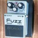 Stříbrný kytarový efekt s černým spínacím pedálem. Na horní části jsou tři ovládací knoflíky a nápisy LEVEL, MODE a FUZZ s možností BOOST. Na přední…