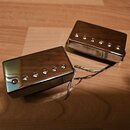 Dva elektrické snímače typu humbucker s chromovaným kovovým krytem. Snímače mají viditelné šestiky pólů a z jejich boku vedou barevné připojovací vod…