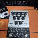 Stříbrný přepínač kanálů s černými ovládacími knoflíky a spodním černým pedalboardem s kovovými spínači. Na horní části je nápis Diezel a označení mo…
