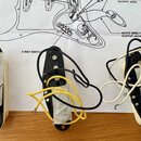 Tři elektrické snímače typu single-coil s černými plastovými kryty a bílým základem. Snímače mají připojovací vodiče v barvách černé, bílé a žluté. N…
