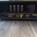 Zadní strana kytarového zesilovače značky Peavey v černém provedení. Jsou vidět čtyři elektronické lampy a ovládací prvky včetně vstupů Effects, Prea…