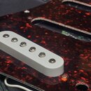 Bílá humbucker snímač s šesti kovovými póly umístěný v červeném vzorovaném pickguardu. Na snímači nejsou viditelné žádné značky ani nápisy. Povrch pi…