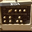 Kytarový kombo zesilovač značky VOX, model MINI5 Rhythm, v krémové barvě s texturovaným povrchem. Na ovládacím panelu jsou knofíky pro Gain, Tone a V…