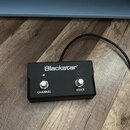 Černý nožní spínací pedal s dvěma kovovými tlačítky. Na horní straně je bílý nápis Blackstar® a pod tlačítky jsou popisy CHANNEL a VOICE. Zařízení je…