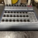 Tmavě modrý USB-MIDI kontrolér s názvem B-CONTROL ROTARY BCR2000. Zařízení obsahuje čtyři řady otočných knoflíků a několik ovládacích tlačítek, v pra…
