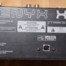 Zadní strana černého míchacího pultu s nápisy XENYX a X1222USB. V levé části je logo behringer, vstup pro napájecí kabel a přepínače POWER ON a PHANT…