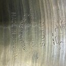 Detail vnitřní strany kovového činely s viditelným rajtováním. Je zde vyražen nápis AVEDIS ZILDJIAN CO GENUINE TURKISH CYMBALS MADE IN CANADA a ornam…