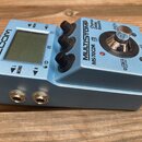 Modrý kytarový efekt s displejem a třemi černými oválovými knoflíky. Na šasi jsou nápisy MULTISTOMP, MS-70CDR a Chorus Delay Reverb. V levé části je…