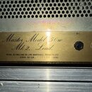 Detail zlatého kovového panelu kytarového zesilovače s nápisem Master Model 50w Mk 2. Lead. Pod tímto textem je uveden nápis MADE IN ENGLAND BY JIM M…