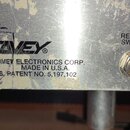Detail stříbrného kovového panelu s logem PEAVEY. Pod ním je text: A PRODUCT OF PEAVEY ELECTRONICS CORP. MERIDIAN, MS MADE IN U.S.A. BUILT UNDER U.S.…
