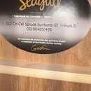 Detailní záběr na oválný štítek uvnitř akustické kytary. Na štítku je žluté logo Seagull a nápisy: Fabriqué au Canada - Made in Canada, S12 CH CW Spr…