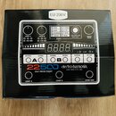 Fotografie znázorňuje krabici s pedalem efektu. Na ní je zobrazen bílý přístroj s nápisy 22500 dual stereo looper a electro-harmonix NEW YORK CITY, U…