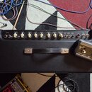 Černý kytarový zesilovač s ovládacím panelem v horní části. Na panelu jsou knofíky s nápisy VOLUME, DRIVE, TREBLE, BASS, MIDDLE, MASTER, REVERB a PRE…