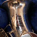 Detail stříbrného saxofonu v modrém pouzdře. Na čáře nástroje je nápis CLASSIC, pod ním SUPER a dále kurzívou Amati Hradec Králové. Dole je uveden te…