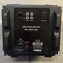 Zadní strana černého basového komba s texturou povrchu a kovovými rohy. Na černé ovládací ploše jsou nápisy BASS COMBO AMPLIFIER a PHIL JONES BASS. J…