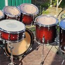 Sada bubnů v tmavě červeném lakovaném provedení s kovovým hardwarem. Na blanách několika bubnů je vidět nápis EVANS. Soubor obsahuje basový buben, ma…