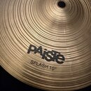 Detailní pohled na mosazný činel s výrazným koncentrickým rýhováním povrchu. Na povrchu je černý nápis PAiste a pod ním text SPLASH 10". Povrch je či…