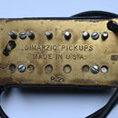 Kytarový snímač s mosazným krytem. Na povrchu je vyražen nápis DIMARZIO PICKUPS MADE IN U.S.A. a níže označení P 2. Povrch krytu vykazuje známky opot…