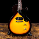 Elektrická kytara s tmelem v provedení sunburst (žlutá až tmhně hnědá). Nástroj má jeden humbucker snímač, černý pickguard a dva zlaté oválné knofíky…