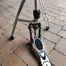 Fotografie zobrazuje bubenový pedál s chromovaným stativem a černou základnou. Na pedálu je viditelné logo Pearl. Povrch pedálu vykazuje známky běžné…