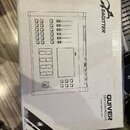 Bílá papírová krabice s černým potiskem. Na povrchu je schéma DMX kontroléru a nápisy SAGITTER, QUIVER DMX CONTROLLER a www.sagitter.com. Rohy krabic…