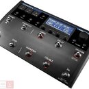 Černý vokální procesor s nápisem TC HELICON a označením VOICE LIVE 2. Zařízení má digitální displej s textem HARMONY WILL SET YOU FREE, několik ovlád…