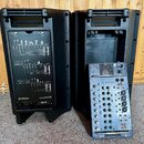 Dvě černé plastové aktivní reproduktory. Na zadní straně levého reproduktoru je nápis YAMAHA a STAGEPAS 500 spolu s návodem k zapojení. Pravý reprodu…