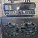 Zadní strana kytarového komba s černým povrchem a kovovými rohy. Na zadním panelu je logo VB a nápisy GUITAR TUBE AMPLIFIER, 50 WATTS RMS / 100 W STE…