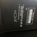 Fotografie zachycuje černý povrch s bílými nápisy a stříbrnou nálepkou. Na nálepce je uveden text SERIAL №: SV-960096 a MADE IN THE CZECH REPUBLIC. V…