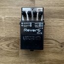 Kytarový efekt reverb v černé barvě s kovovým šasi. Na horní části jsou tři ovládací knoflíky a nápisy CHECK, MODULATE, SPRING, PLATE, HALL, ROOM, SH…