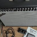 Černý kytarový kombozesilovač s šedou textilní mřížkou a stříbrným lemováním. Na ovládacím panelu je nápis Twin Reverb-Amp a FENDER MUSICAL INSTRUMEN…