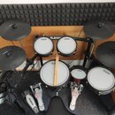 Elektronická bicí souprava značky Alesis s černým rámem a bílými bubny. Na bubnech jsou viditelné nápisy ALESIS STRYKER. Součástí sady jsou čtyři čer…