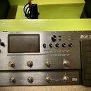 Stříbrný kytarový procesor s nápisem GE 300 a doplňkem Amp modelling & Stomp & Multi Effects. Zařízení má displej, několik otočných ovladačů a řadu s…