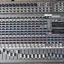 Šedý mixovací pult s nápisy SAMSON a 24 DSP. Pod logem je uveden model TXM80 1000W STEREO POWERED MIXER. Na ovládacím panelu jsou řady bílých a modrý…