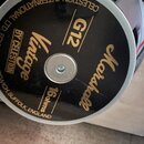 Záběr na zadní stranu reproduktoru s černým krytem. Jsou zde zlaté nápisy Marshall, G12 Vintage BY CELESTION a 16ohms. Po obvodu je bílý nápis CELEST…