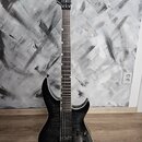 Černá elektrická kytara s prosvítajícím žilováním dřeva na těle. Na hlavě hmatníku je bílý nápis LTD Deluxe. Nástroj má dva humbuckery, jeden ovládac…