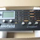 Šedý desktopový syntetizátor s nápisy blofeld SYNTHESIZER a waldorf. Přístroj má displej, několik ovládacích knoflíků a řadu tlačítek s popisky jako…