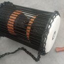 Černý buben s dřevěným korpusem v hnědé barvě, který je opleten černými šňůrkami. Na bílé membráně je viditelné černé logo "MEINL". K nástroji patří…