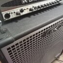 Kombinovaný basový zesilovač s integrovaným reproduktorem. Na horním panelu je nápis GK GALLIEN-KRUEGER a červený text BI-AMP BASS AMPLIFIER. Přední…