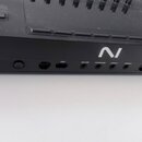 Detail zadní strany černé klávesové ovládací plochy. Na povrchu je bílé logo "NI" a řada konektorů s popisky: "ONLY", "SUS/AIN", "EXPRESSION", "ASSIG…