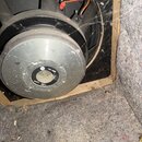 Zadní pohled na černý reproduktor s kovovým magnetem stříbrné barvy. Na zadní straně magnetu je nápis RCF a L18-900, dále text MADE IN ITALY. K repro…