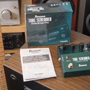 Zelený kytarový efekt pedál s nápisy TUBE SCREAMER, Overdrive Pro TS808DX a Ibanez. Vedle pedálu je položen původní krabicový obal s identickými nápi…